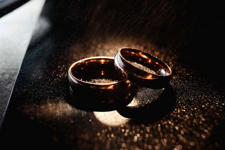 Elegant wedding rings are made of gold. Close-up, macro. Dark backgroundの写真素材