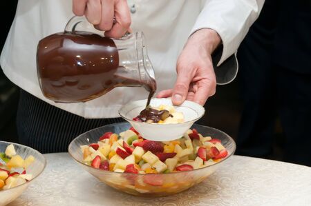 A butler serving hot chocolate with fruit saladの写真素材