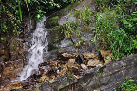 Small natural waterfall falling over rocks, Guangxi, Chinaの写真素材