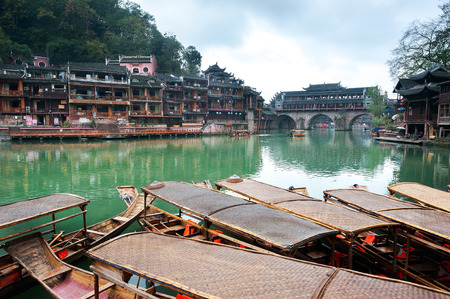 Moored rowing boats on the Tuojiang river, Fenghuang ancient town, Chinaの写真素材