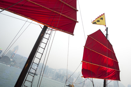 VICTORIA HARBOUR, HONG KONG - MARCH 20, 2014 - Traditional red-sailed Chinese junk in Victoria Harbour, Hong Kongのeditorial素材