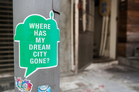 Sticker on a Hong Kong lampst asking "Where has my dream city gone?"の写真素材