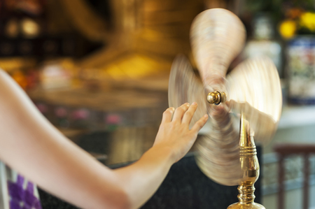 TAI WAI, HONG KONG - SEPT 15, 2013 - Worshipper at Che Kung Temple, Tai Wai, spinning a brass wheel of fortuneのeditorial素材