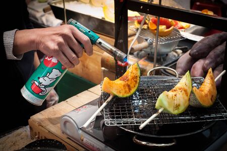 Grilled cantaloupe melon at Kuromon Ichiba Market in Osaka, Japanのeditorial素材