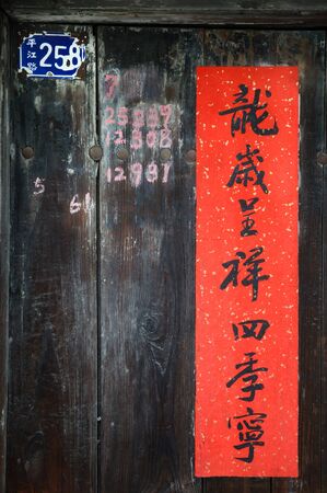 Chinese new year poem on an old wooden door on Pingjiang Road, Suzhou, China. The banner reads 'dragon brings prosperity for four seasons'. The address reads '258 Pingjiang Road'.のeditorial素材