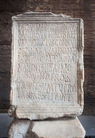 Ancient marble tablet engraved with the Venantius incription inside the Colosseum in Rome, Italy. The inscription commemorates the restoration of the Colosseum's podium and arena, at his own expense, by Decius Marius Venantius Basilius after an earthquakeのeditorial素材