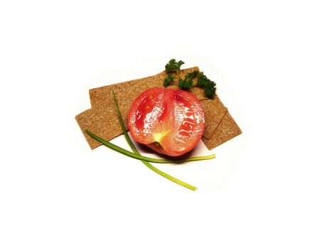 red tomato with crispbreads, spring onions and green parsley over white backgroundの写真素材