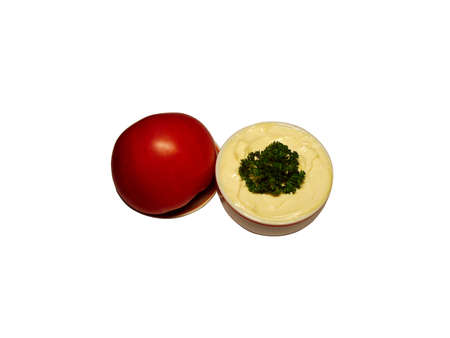 mayonnaise in souce-boat with tomato on saucer over white backgroundの写真素材