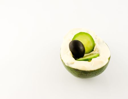 mayonnaise over avokado with black olive over white background  