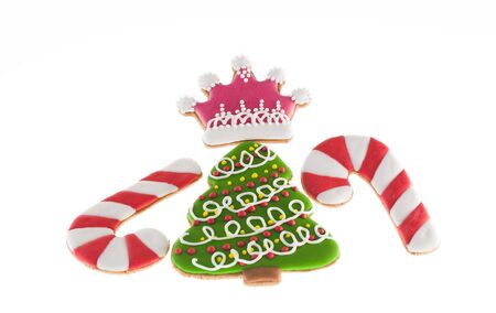 Christmas cookies xmas tree, two canes and pink crown over white backgroundの写真素材