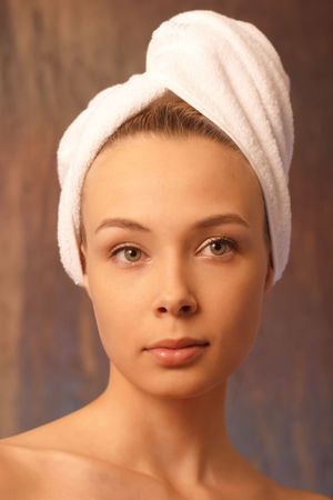 Front portrait of the girl with towel on a headの写真素材