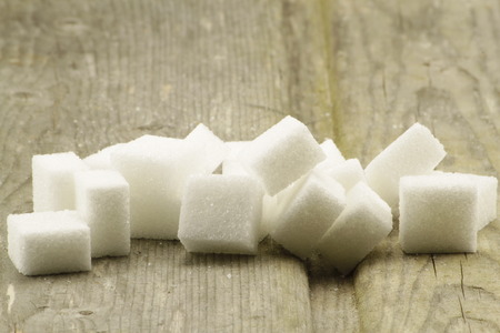 Sugar cubes in front of wood backgroundの写真素材
