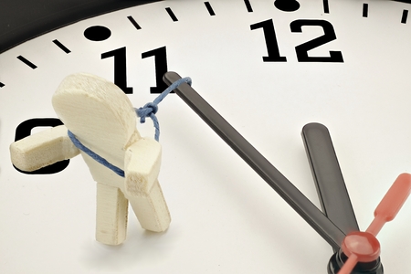 Working against the time - symbol with clockの写真素材