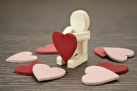 Wooden man with many red and pink heartsの写真素材
