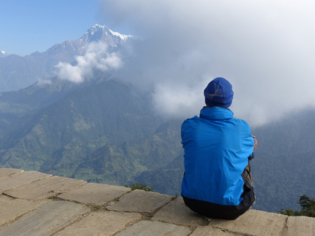 Hiker looking to the mountain on Poon Hill, Annapurna range on the backround - one of the most visited Himalayan view points in Nepal, view to snow capped Himalayaの写真素材