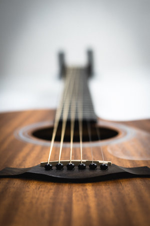 Acoustic guitar on a wooden background, shallow depth of field.