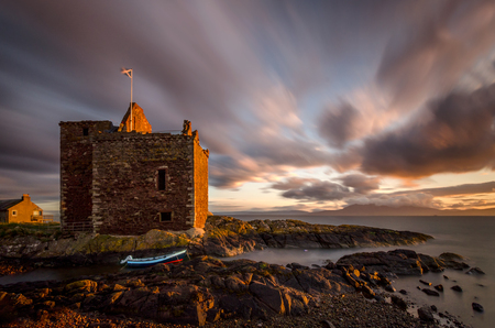 Portencross, Scottish castle on coastline in susnset lightの写真素材