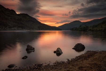 Three stones on quiet Loch Eck in sunset light, Scotlandの写真素材
