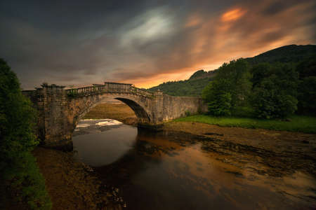 Garron Bridge over the Gearr Abhainn river in sunset orange light, Highlands Scotland