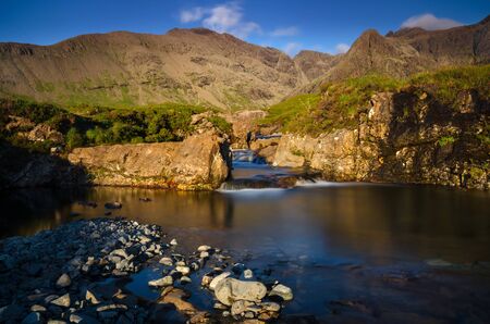 Fairy Pools waterfalls with Cuillin Mountains in sunset light, Isle of Skye, Scotlandの写真素材