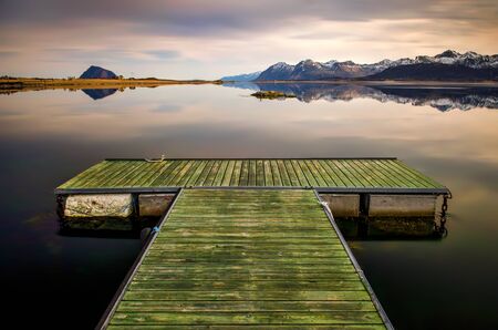 Pier on Limstrandpollen fjord with Hoven mountain in background, Lofotenの写真素材