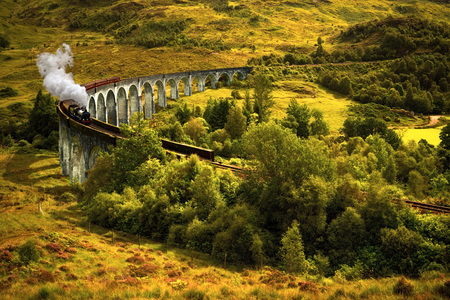 Jacobite steam train on old viaduct in Glenfinnan, Scotlandの写真素材