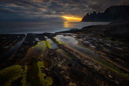 Tugeneset rocky coast with mountains in background at sunset, Norwayの写真素材