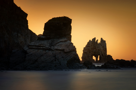 Playa de Portizuelo rocky coast with cliffs in background at sunset, Asturias, Spainの写真素材