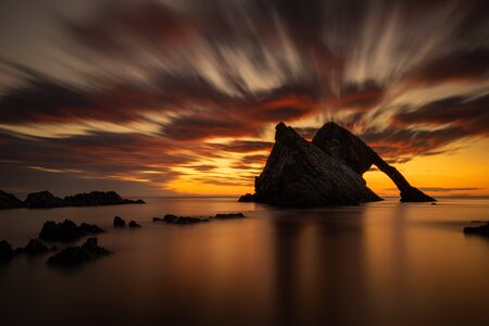 Bow Fiddle Rock reflection in sunrise light, Portknockie, Scotland