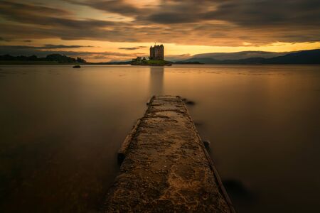 Stalker Castle pier in orange evening light, Highlands, Scotlandの写真素材