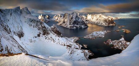 View from Reinebringen summit on Reine village and fjord in snowy winter, Lofotenの写真素材