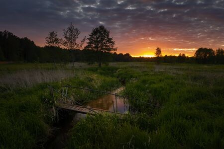 Footbridge on Wymakracz river in sunset light, Polandの写真素材