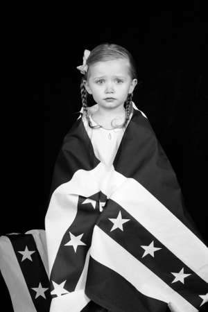 A girl clothed in an American flag design.  The photograph is in black and white.の写真素材