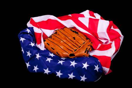A baseball glove resting on an American flag.  American supports baseball.の写真素材