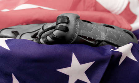 An old baseball glove in black and white and an American Flag.の写真素材