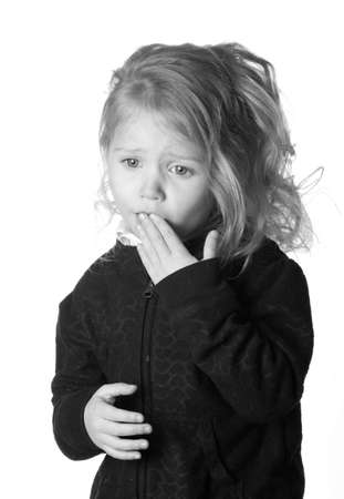 A black and white photograph of  a girl who could be expressing numerous emotions.の写真素材