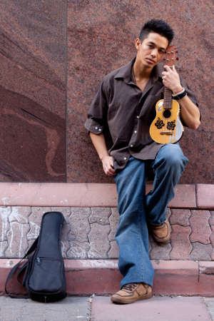 A photograph of a handsome young man with his Ukeleleの写真素材