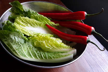 Malang, Indonesia - June 19, 2021 : mustard greens and red chilies in a stainless steel potの写真素材