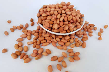 Malang, Indonesia - Dec 21, 2019 : a bowl of peanuts and some spilled around itの写真素材