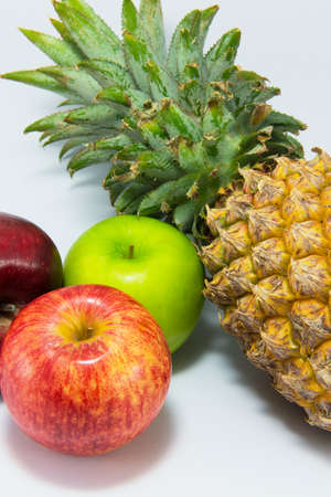 Three apples and pineapple isolated on white background.の写真素材