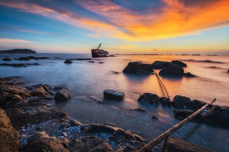 Natural seascape view with wreck ship at sunsetの写真素材