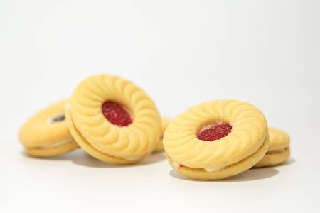 Butter cookies with strawberry jam filling on the top isolated on white backgroundの写真素材