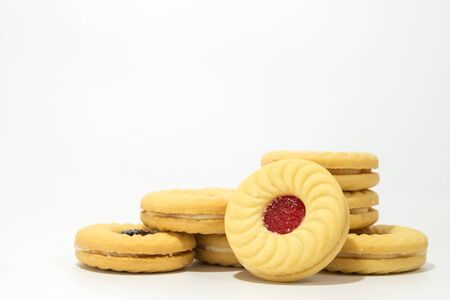 Butter cookies with strawberry jam filling on the top isolated on white background