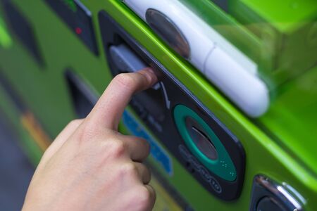 Finger pushing refund bar on vending machineの写真素材