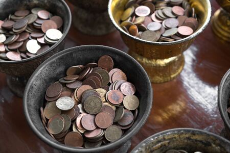 Black Buddhist monk's alms bowl in row line, for putting coins to bowls for luckの写真素材