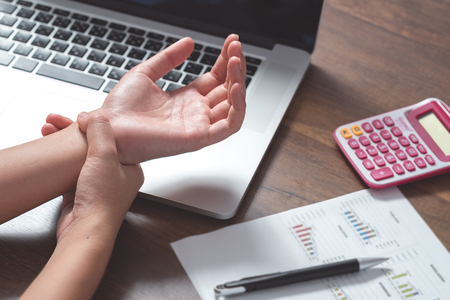 A young office woman got wrist painの写真素材