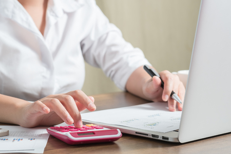 Close up female accountant or banker making calculations. Savings, finances and economy conceptの写真素材