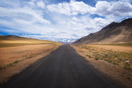 Road in mountain Himalayas and dramatic clouds on blue sky. Ladakh, Jammu and Kashmir, Indiaの写真素材