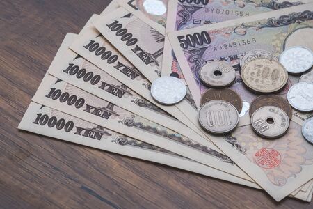 Japanese yen, Japanese currency bank notes and coins on tableの写真素材
