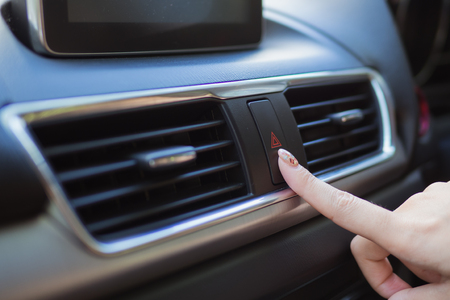 Close up finger hitting car emergency light botton in carの写真素材